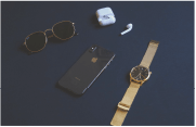 High value items such as Apple AirPods, iPhone, luxury watch and sunglasses layed out
