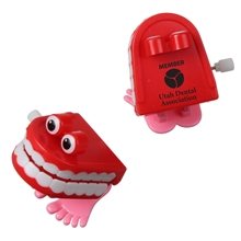 a red/pink wind - up chattering teeth toy with eyes