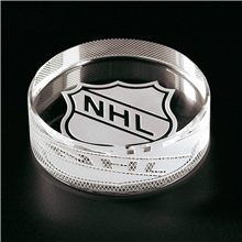 a clear crystal hockey puck paperweight